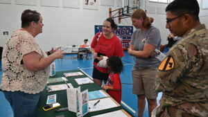 Allie Colby, parent ambassador for Hill Country Arts Academy, shares resources with families during the Homeschool Resource Fair Aug. 28 at the Bronco Youth Center.(U.S. Army photo by Janecze Wright, Fort Hood Public Affairs)