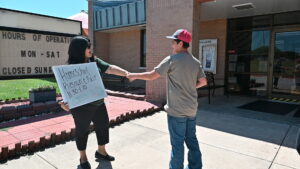 Tony Frame, 14, is greeted by school liaison officer Leticia Sanchez outside the Homeschool Resource Fair Aug. 28 at the Bronco Youth Center on Fort Hood.(U.S. Army photo by Janecze Wright, Fort Hood Public Affairs)