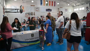 Leticia Sanchez and Kristine Caparco, school liaison officers with Fort Hood Child and Youth Services, welcome families during the Homeschool Resource Fair Aug. 28 at the Bronco Youth Center.(U.S. Army photo by Janecze Wright, Fort Hood Public Affairs)