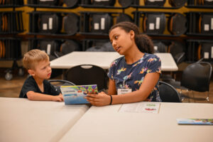 Esther Matlock, 14, a youth volunteer, and Benaniah Carter, 5, discuss a pamphlet at Awana Club during the Community Connections program Sept. 4 at the Fort Hood Main Post Chapel. The classes were divided into different age groups from preschool to adults. (U.S. Army photo by Derika Upshaw, Fort Hood Public Affairs)